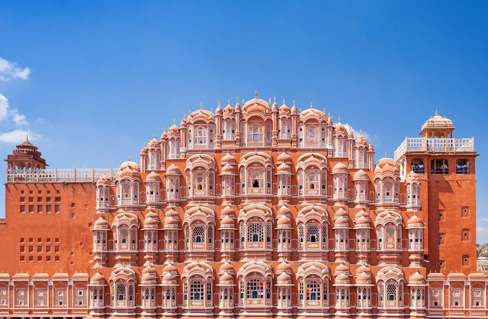 Hawa Mahal facade in Jaipur with rows of small arched windows and pink sandstone architecture