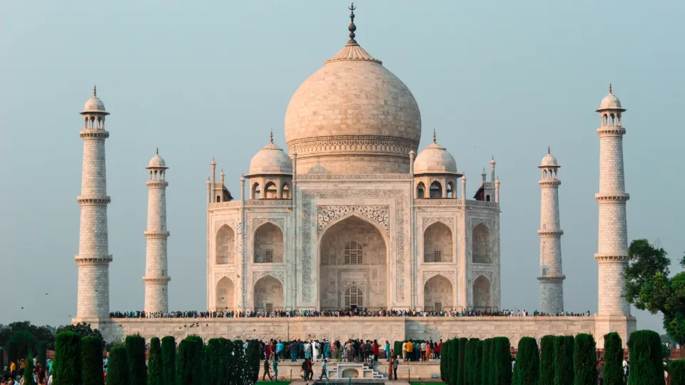 Taj Mahal front elevation with central dome flanked by four minarets and visitors below