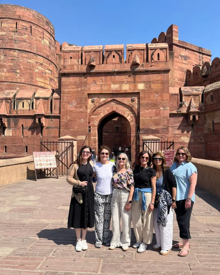Group of Farbound guests standing at the red sandstone main gate of Agra Fort