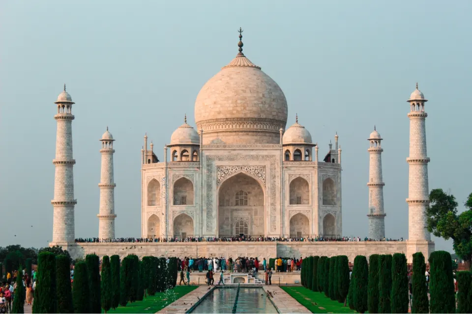 Wide view of the Taj Mahal complex with minarets and the long reflecting pool in front