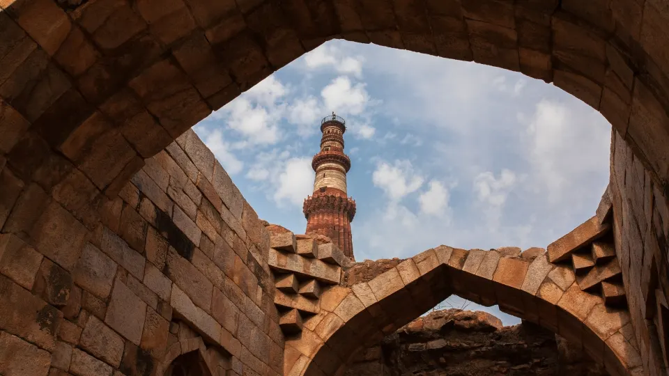 Qutub Minar framed through a stone archway