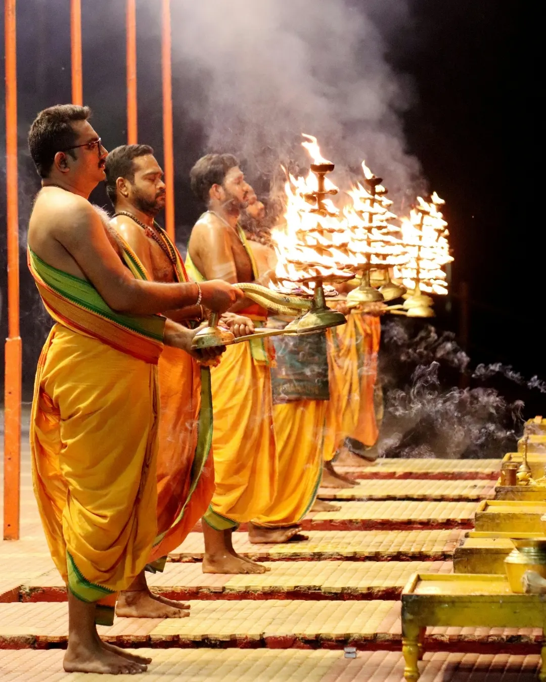 Night-time Ganga aarti ceremony with fire lamps and crowds on the Varanasi ghats