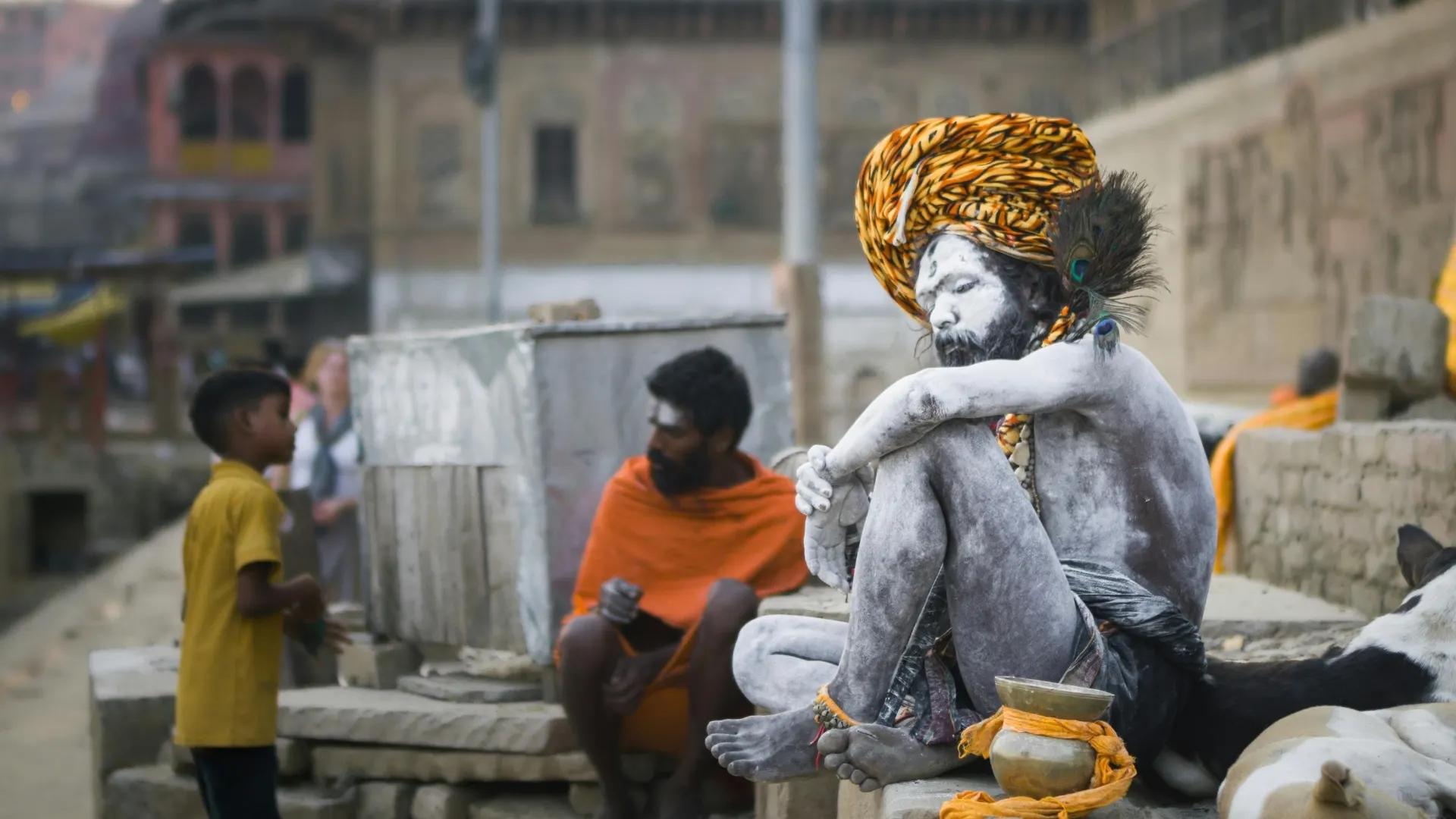Sadhu resting along a ghat-side street scene in Varanasi