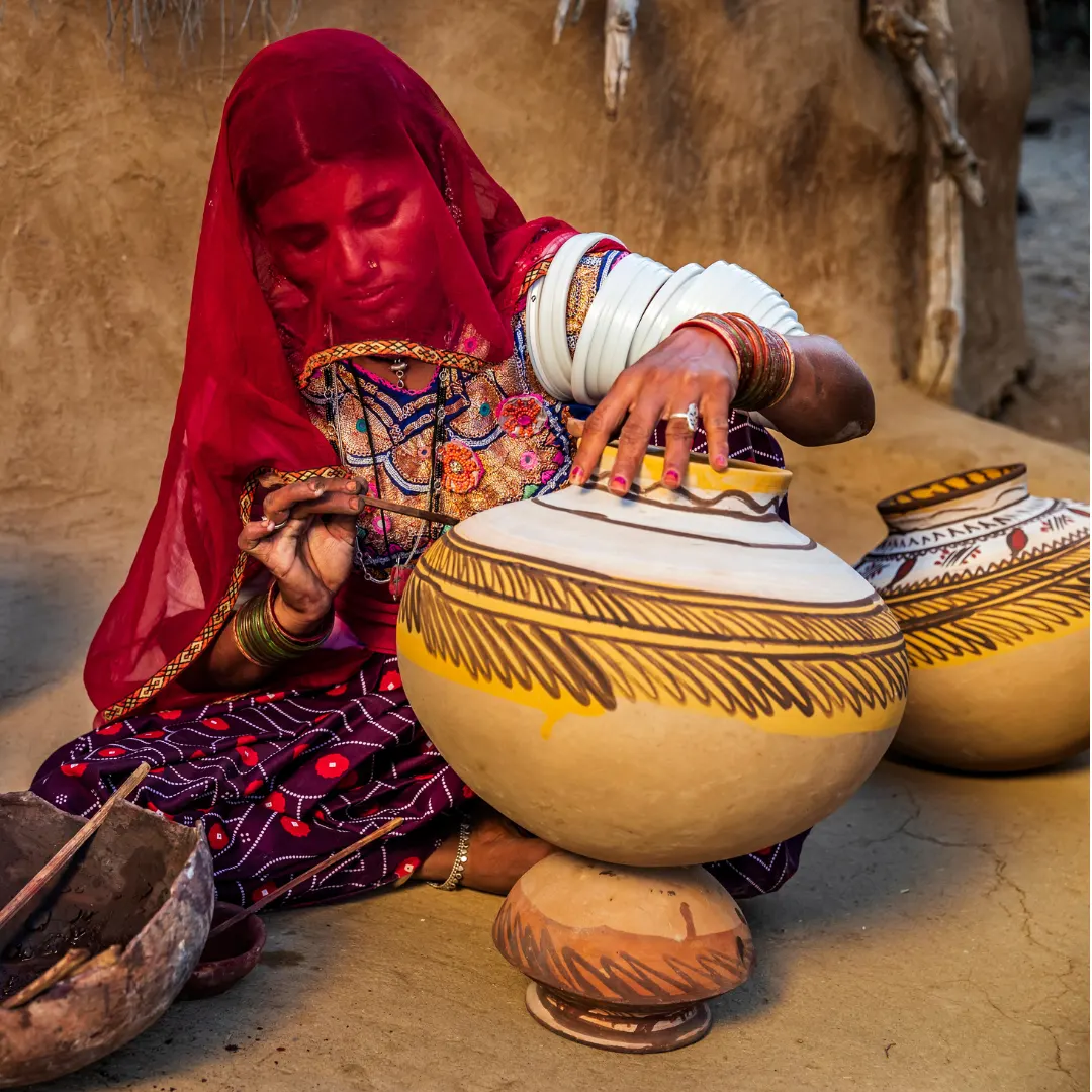 Rajasthani woman hand painting traditional clay pot