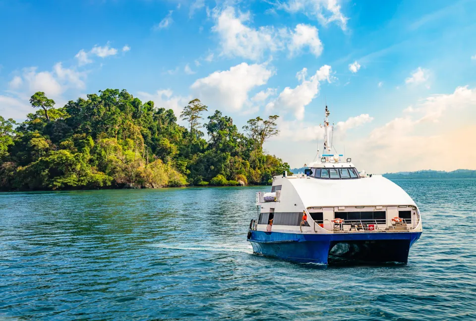 passenger ferry approaching a forested island near port blair