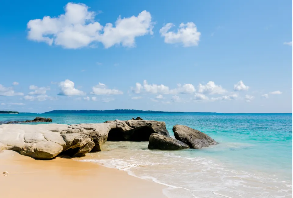 rocky shoreline with clear water and sandy beach in havelock