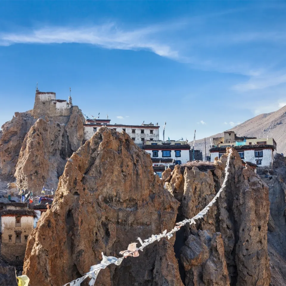 Cliffside Ladakhi village with prayer flags strung across rock formations