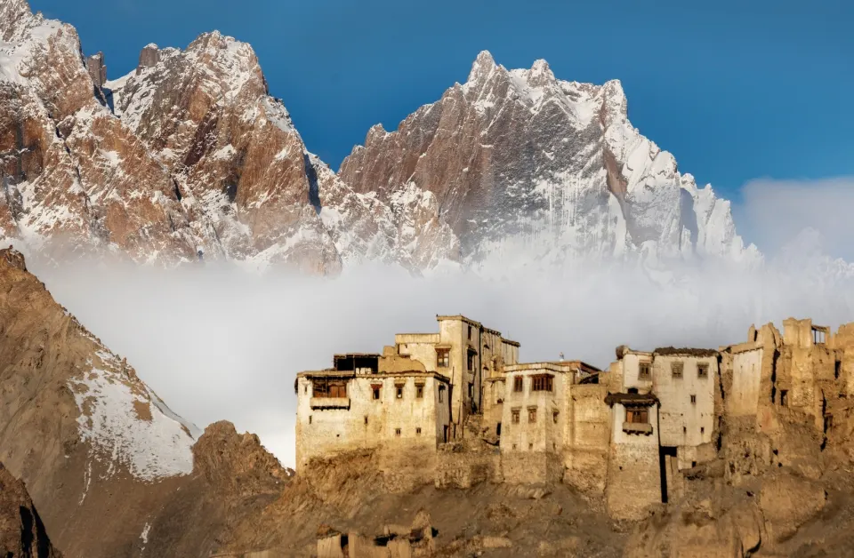 Fortified Ladakhi village beneath snow-covered Himalayan peaks