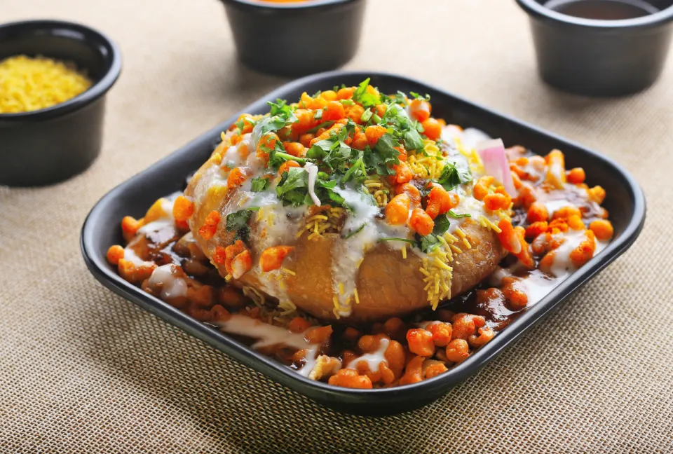 raj kachori topped with yogurt and chutneys