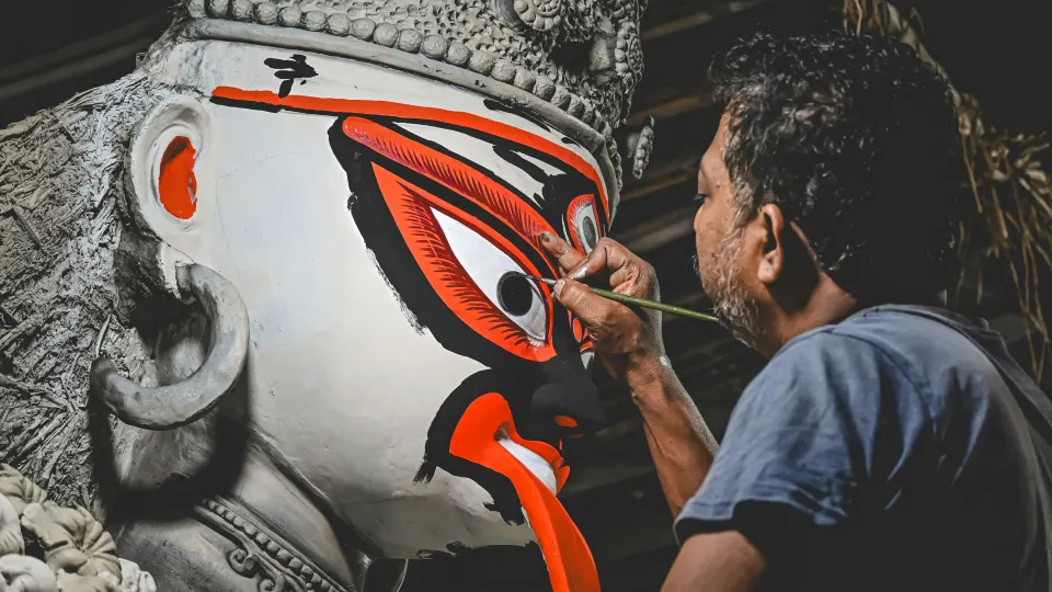 artist painting eyes of durga idol