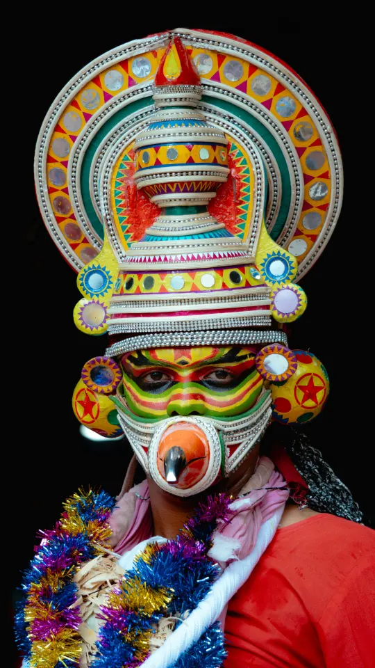 Yakshagana performer with elaborate facial makeup and ornaments