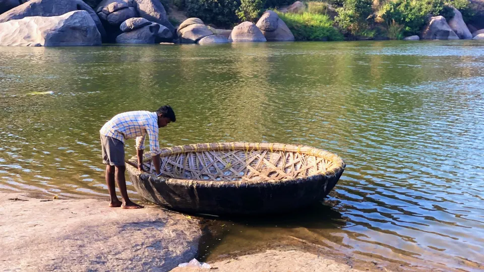 Coracle floating on the Tungabhadra River amid Hampi’s rocky landscape