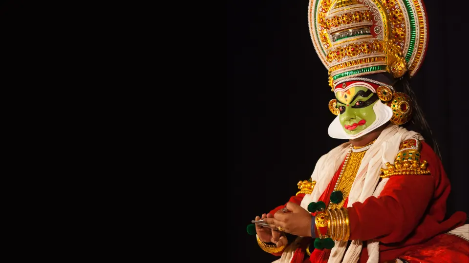 A Kathakali performer in elaborate traditional costume on stage
