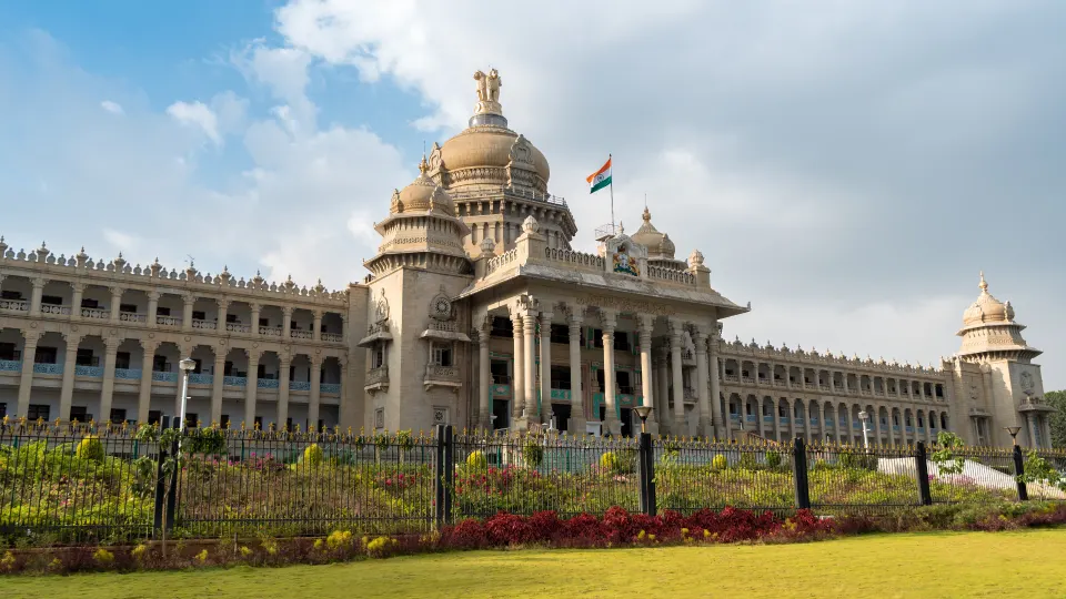 Front view of Vidhana Soudha in Bengaluru with a partly cloudy sky