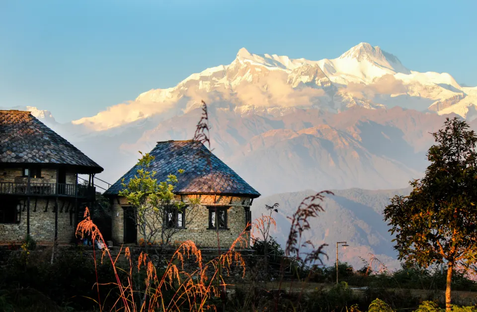 A mountain lodge with the Annapurna range glowing in sunrise light