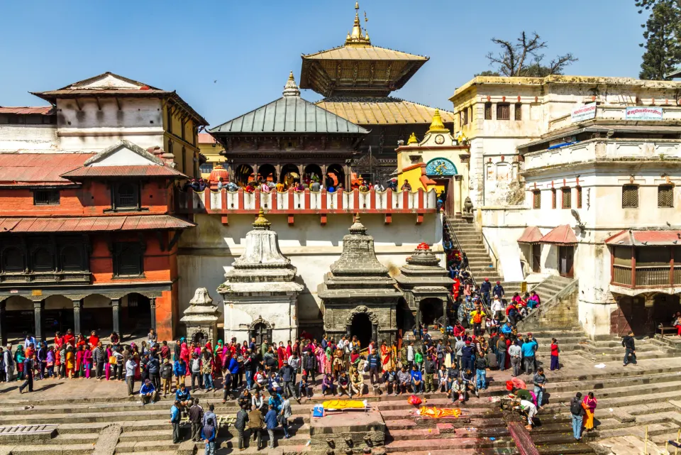 Crowds gathered along the ghats at Pashupatinath Temple with shrines and pagoda-style roofs in the background