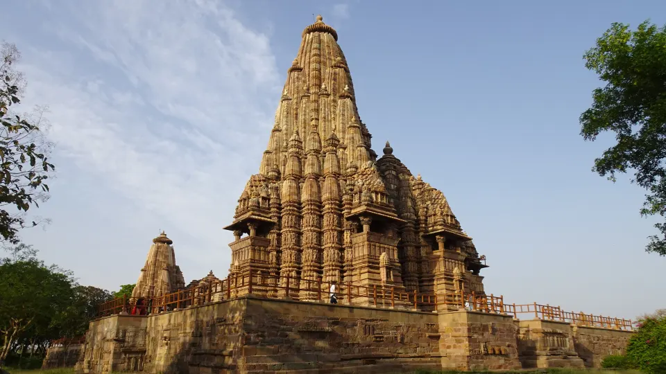 Side view of a Khajuraho temple with intricate carvings and shikhara tower