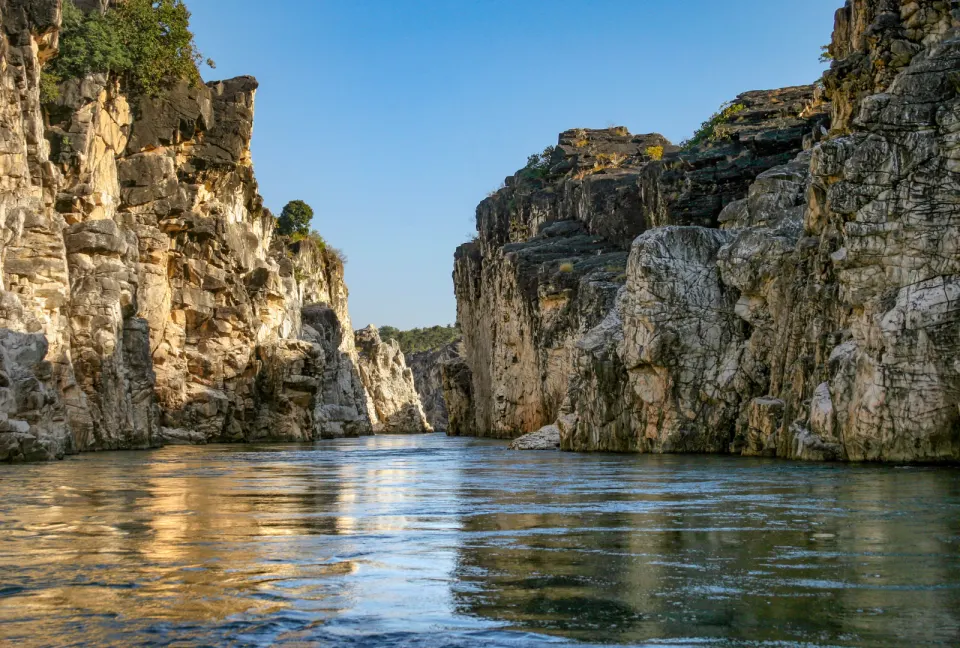 White marble cliffs rising above calm water at the Marble Rocks in Jabalpur