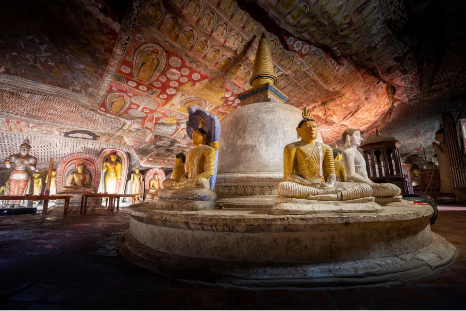 Buddha statues and painted cave ceiling inside Dambulla Cave Temple